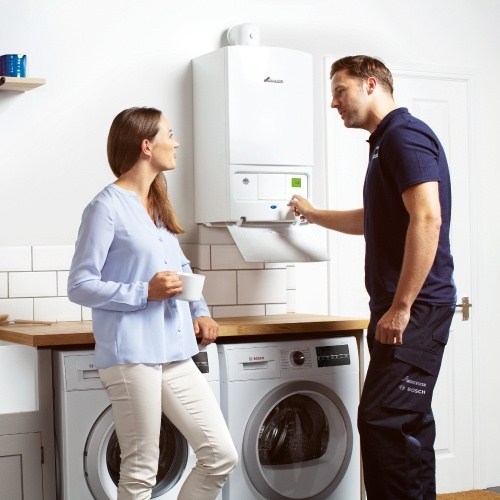 boiler engineer servicing a gas boiler in a home