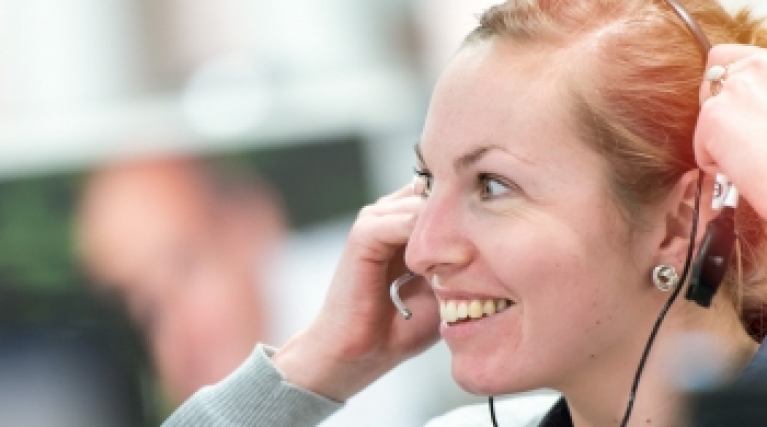Smiling lady in a call centre wearing a headset