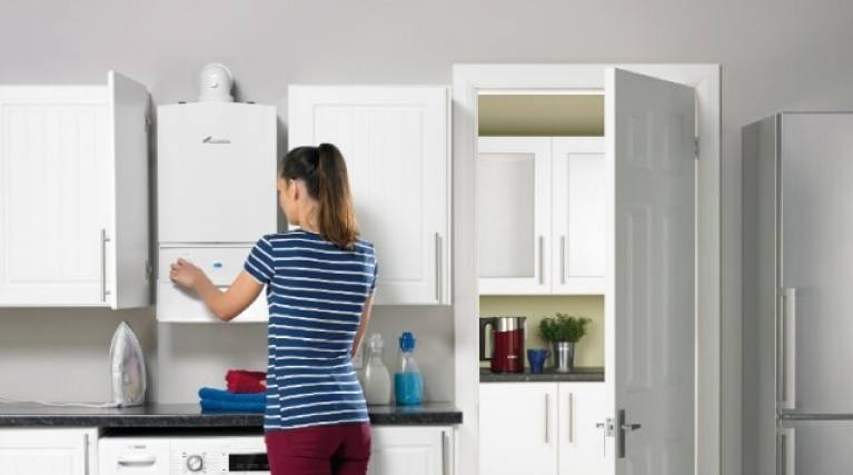 lady in a kitchen with a white gas boiler