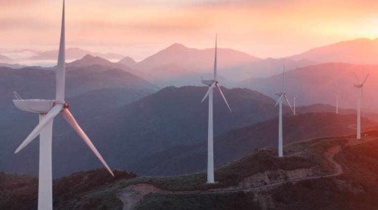 Image of six windmills at sunset generating renewable electricity